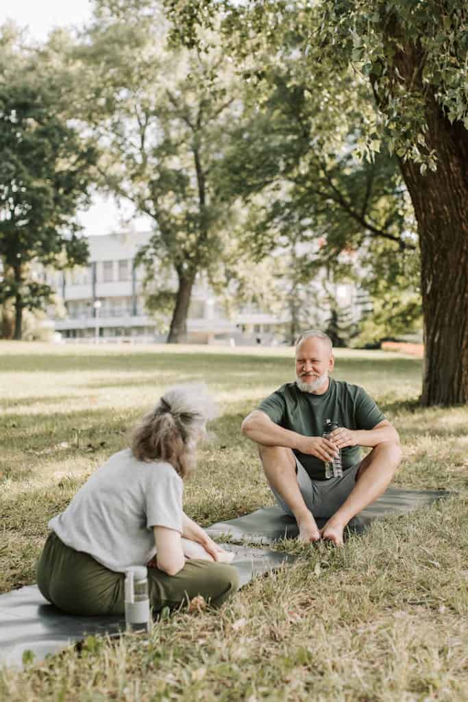 Elderly Couple Sitting on Yoga Mats
